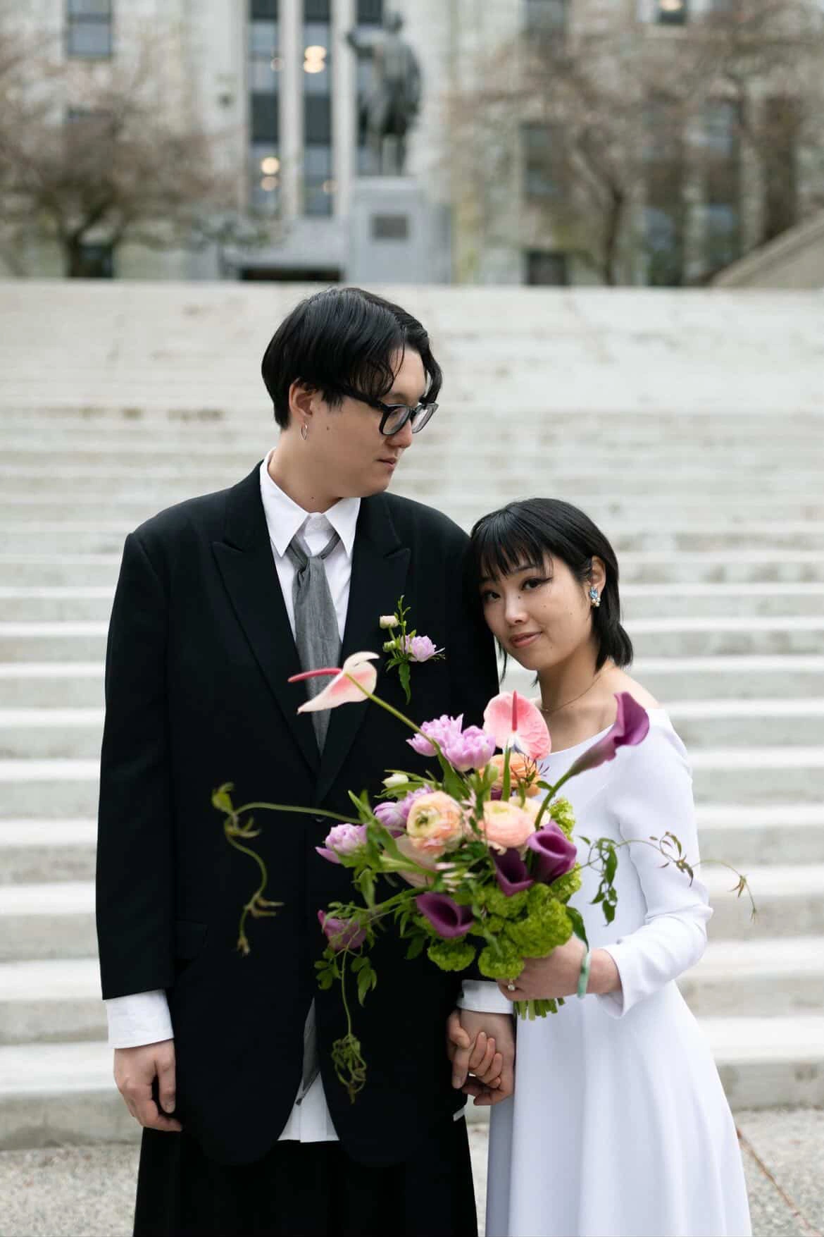 Couple holding the Rita bridal bouquet and matching boutonnière